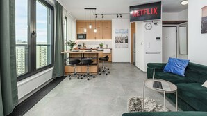 A modern apartment with a kitchen, dining area, and living space. A large window provides a view of the city. - Warsaw Flat With Balcony (Warsaw)