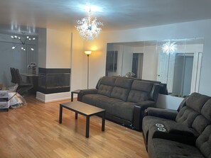 A living room with a fireplace, a sofa, a coffee table, and a large mirror. - Spacious 4BR; 2.5BR; en-suite;FL basement;appliances;central air& heat included! (Chicago)