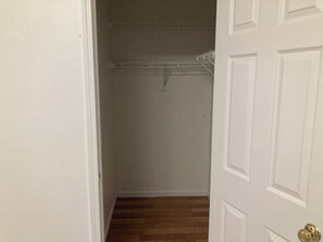 A narrow hallway with a wooden floor leading to a closet with a white door. - Spacious 4BR; 2.5BR; en-suite;FL basement;appliances;central air& heat included! (Chicago)