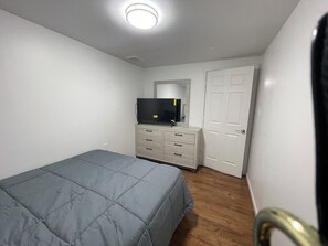 A bedroom with a bed, a dresser, a television, and a door. - Spacious 4BR; 2.5BR; en-suite;FL basement;appliances;central air& heat included! (Chicago)