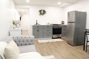 A modern kitchen with grey cabinets, a stainless steel refrigerator, and a coffee machine. - Cozy 1-bedroom apartment in wonderful Berlin with AC (Millersburg)
