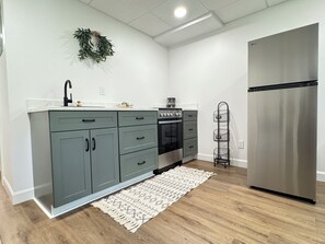 A modern kitchen with grey cabinets, a stainless steel refrigerator, and a built-in oven. - Cozy 1-bedroom apartment in wonderful Berlin with AC (Millersburg)