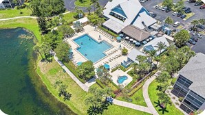 An aerial view of a resort with a large central pool, multiple smaller pools, and a parking area. - The Divine Tides Condo 5 Min Walk to Jupiter Beach (Jupiter)