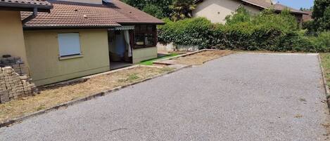 Uma rua residencial com casas, um caminho de acesso pavimentado e uma área gramada.