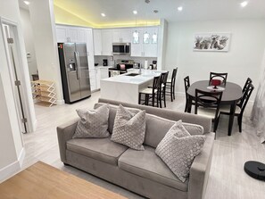A modern kitchen with white cabinets, a built-in microwave, and a stainless steel refrigerator. - Cozy 2-bedroom pet friendly family home in central Margate with pool access. (Margate)