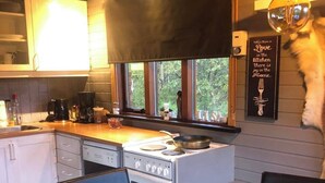 Una cocina con estufa, lavamanos y comedor.