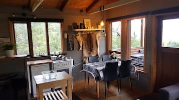Ein rustikales Interieur mit Essbereich, Küche und einem großen Fellteppich.
