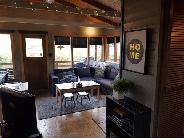 A cozy living room with a sofa, a coffee table, and a fireplace.