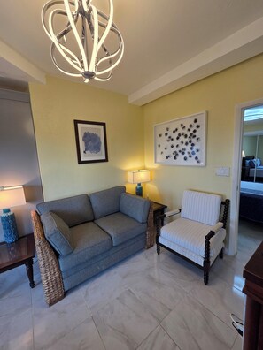 A living room with a sofa, a chair, a lamp, and a wall art piece. - Newly Renovated Luxury Mountain Top Retreat 2BR 2BA Sleeps 4 (st thomas)