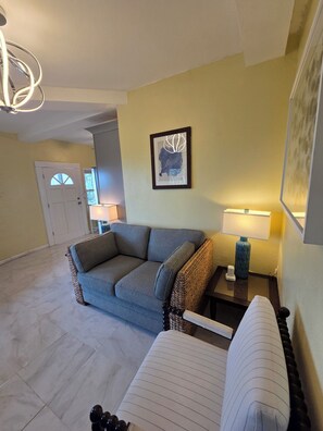 A living room with a sofa, a side table, a lamp, and a framed artwork on the wall. - Newly Renovated Luxury Mountain Top Retreat 2BR 2BA Sleeps 4 (st thomas)