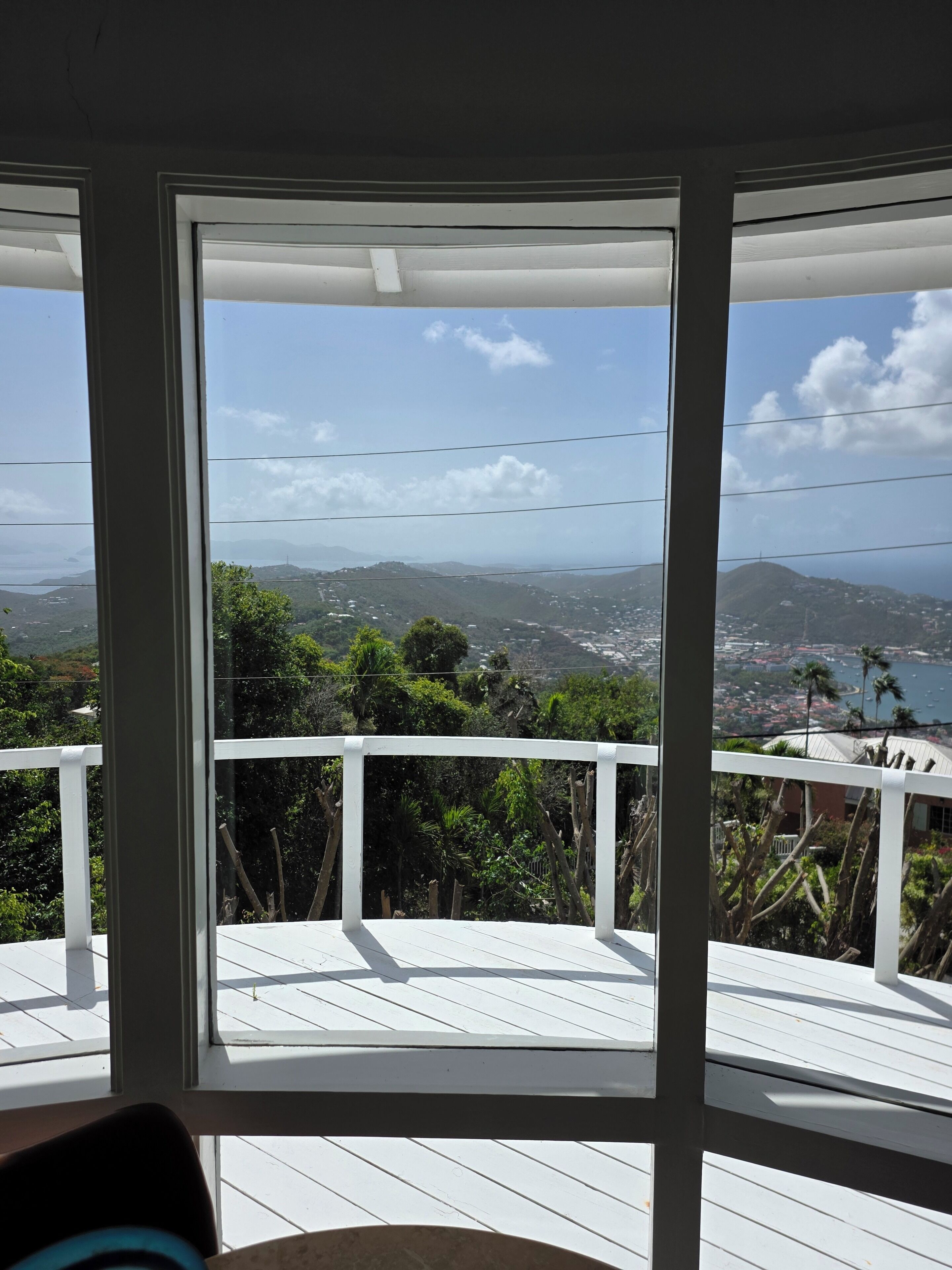 A room with a large window overlooking a scenic view of hills and a body of water.