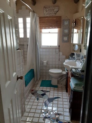 Ein Badezimmer mit Toilette, Waschbecken und Duschbereich.