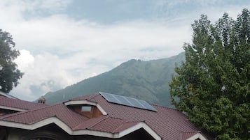 A building with a sloped roof, multiple windows, and a visible solar panel.