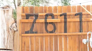 Une clôture en bois sur laquelle est peint le numéro « 7611 ».