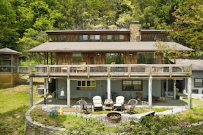 A two-story wooden house with a balcony, outdoor seating, and a fire pit. - Cozy 1-bedroom apartment in charming Sky Valley, GA. 11 miles from Highlands, NC (Dillard)