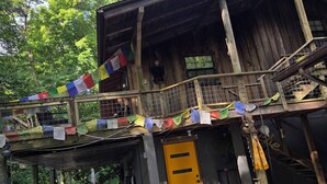 A rustic wooden building with a yellow door, a staircase, and a balcony. - Cozy 1-bedroom apartment in charming Sky Valley, GA. 11 miles from Highlands, NC (Dillard)