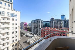Ein Hochhaus mit mehreren Balkonen und freiem Blick auf die Stadtlandschaft.