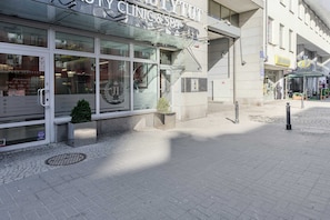 A building with a large glass facade, a sign reading 'CLINIC & SPA,' and a small potted plant in front. - Central Warsaw Home With Garage (Warsaw)