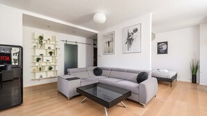 A modern living room with a grey sectional sofa, a black coffee table, and a minimalist design. - Central Warsaw Home With Garage (Warsaw)
