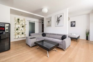 A modern living room with a grey sectional sofa, a black coffee table, and a minimalist design. - Central Warsaw Home With Garage (Warsaw)