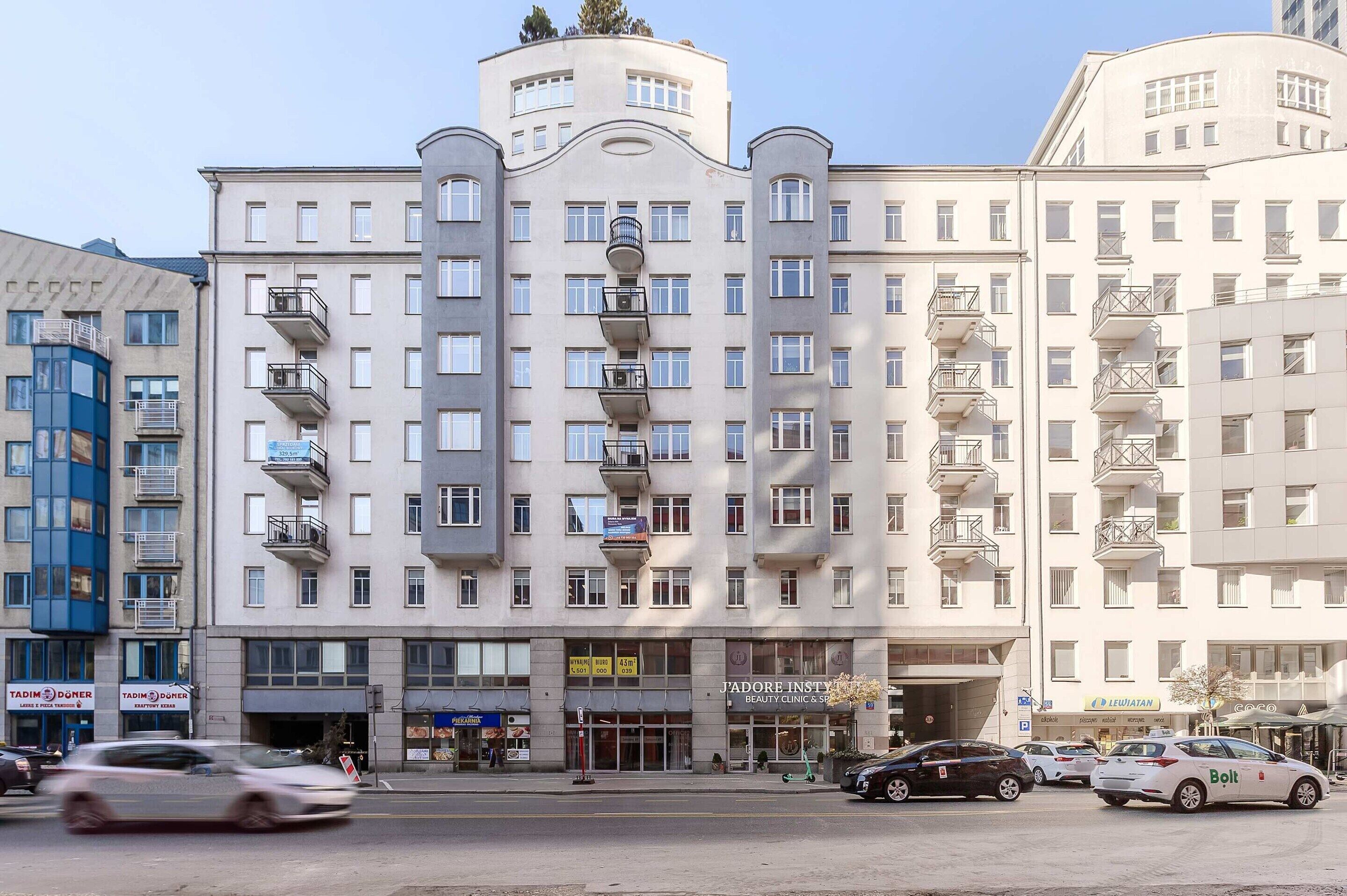 Ett hotell med flera våningar, balkonger, en restaurang på markplan och en väl synlig entré.