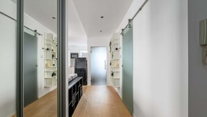 A hallway with a kitchen area, wooden flooring, and built-in shelving units. - Central Warsaw Home With Garage (Warsaw)