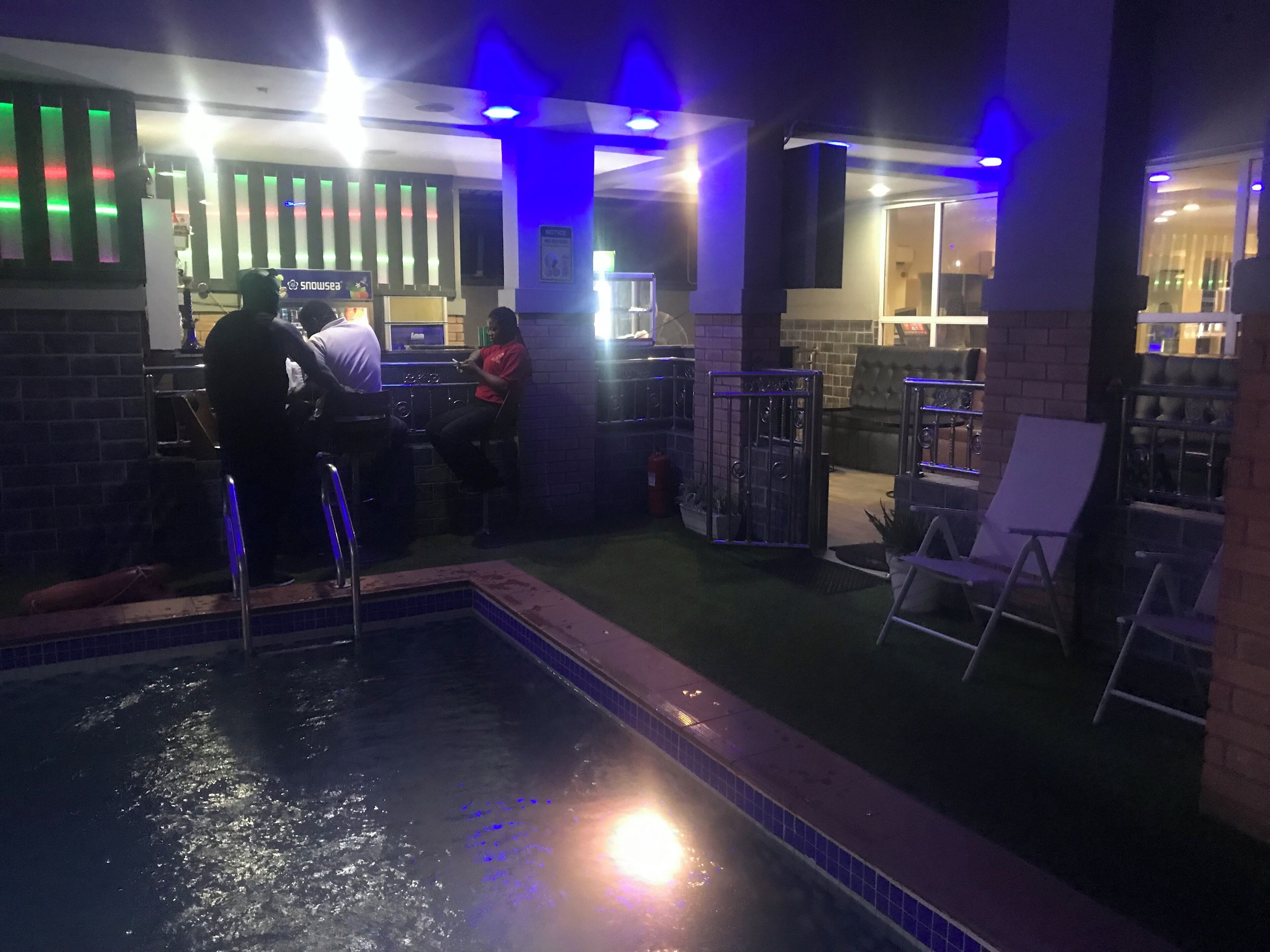 Área interna da piscina com bar e assentos.