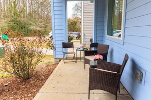 A patio with wicker furniture, a small table, and chairs. - Luxy-Master BRD Down - 7Beds - Near CLT Uptown (Charlotte)