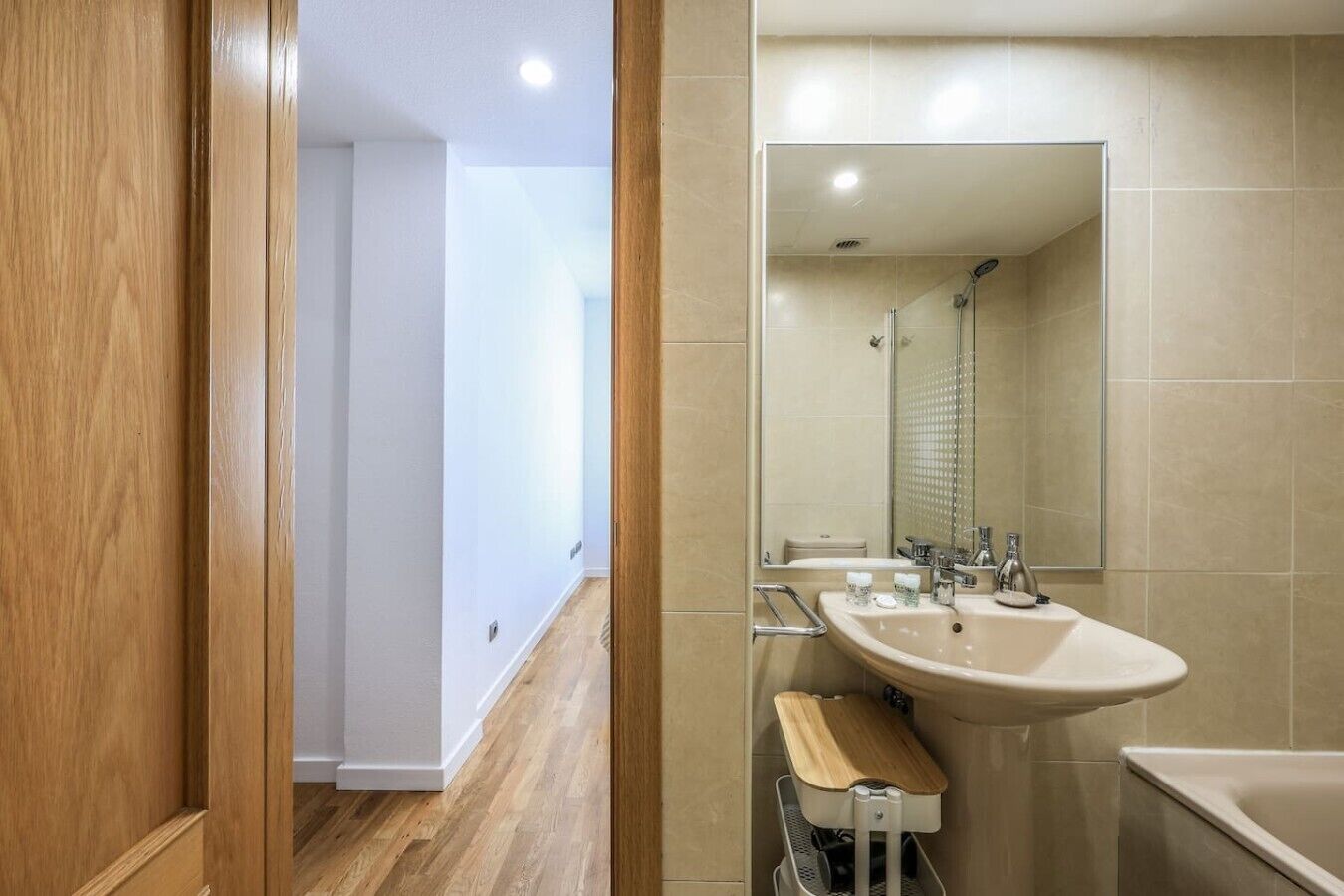 Un baño moderno con un lavamanos grande, un espejo y una zona de ducha.
