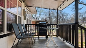 A covered porch with a grill and chairs. - Adorable 3-bedroom house with in minutes I-40 and half a mile from 540 (Fort Smith)