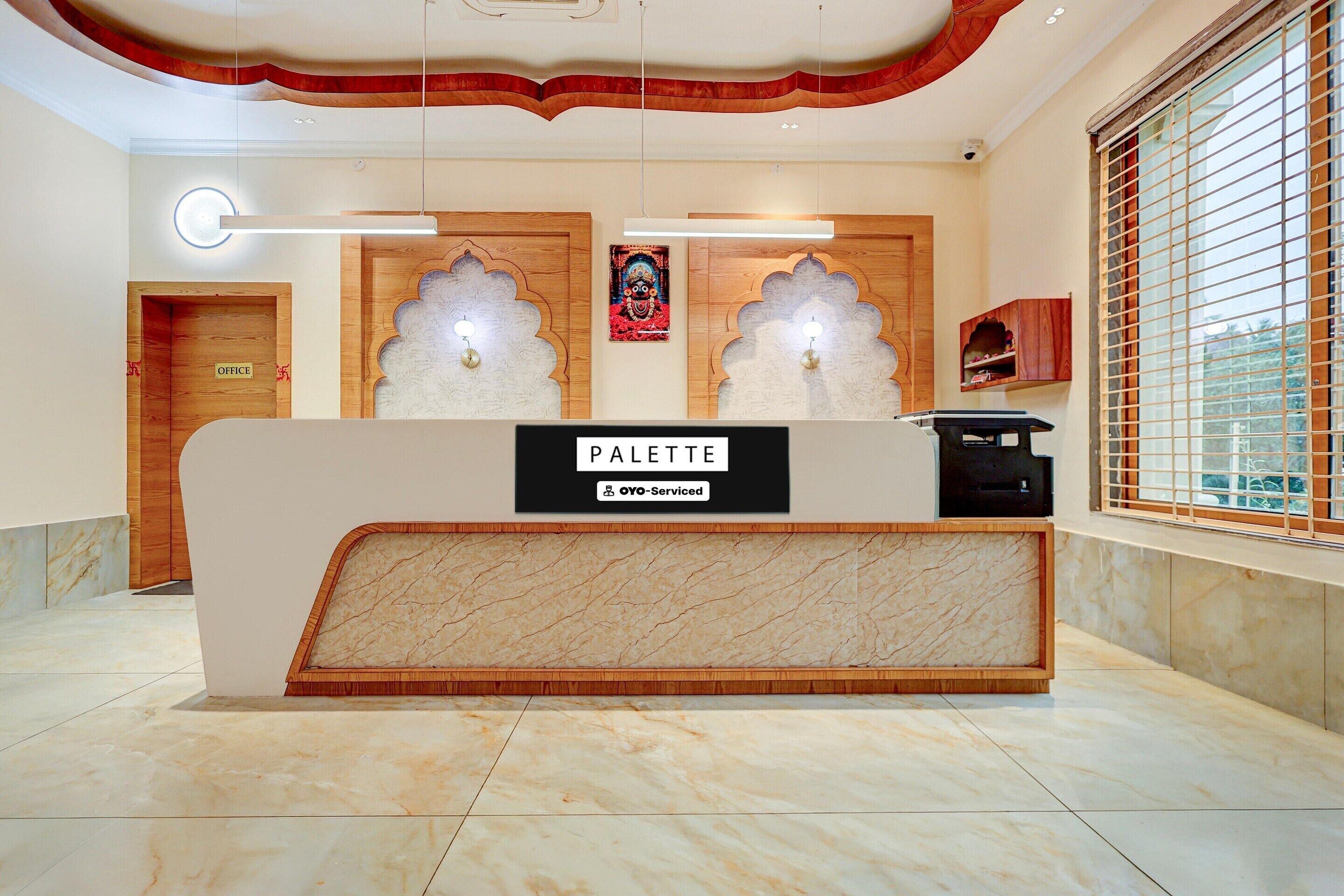 A reception desk with a sign reading 'PALETTE' and a sign indicating 'OFFICE' to the left.