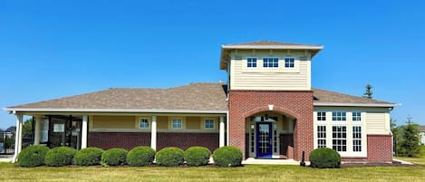 A two-story house with a prominent brick section and a separate tower-like structure on the roof.