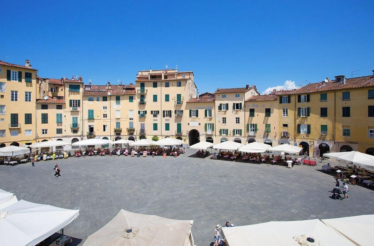 A courtyard with outdoor seating and buildings with balconies.