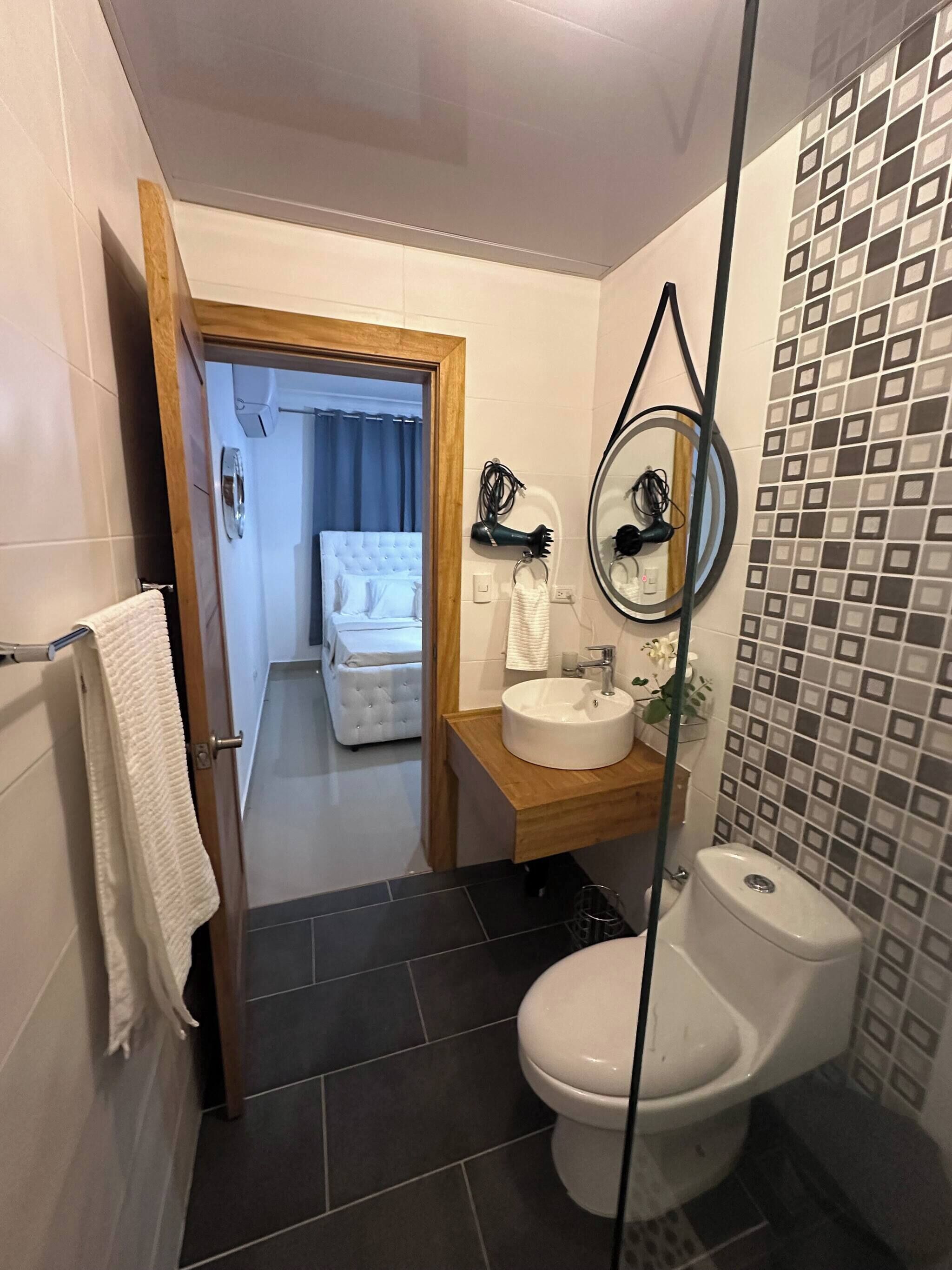 A bathroom with a toilet, sink, and shower area.