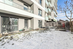 A modern multi-story residential building with large windows and balconies. - Family Flat With Garden (Warsaw)
