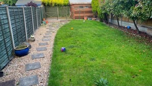 A backyard with a fenced area, a shed, and a grassy lawn. - Modern 3BR Home with Free Parking | Sleeps 6 | Family & Business Friendly (Bracknell)