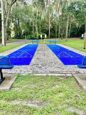 A park with a shuffleboard court, benches, and trees. - 2-bedroom RV in Crystal River (Crystal River)