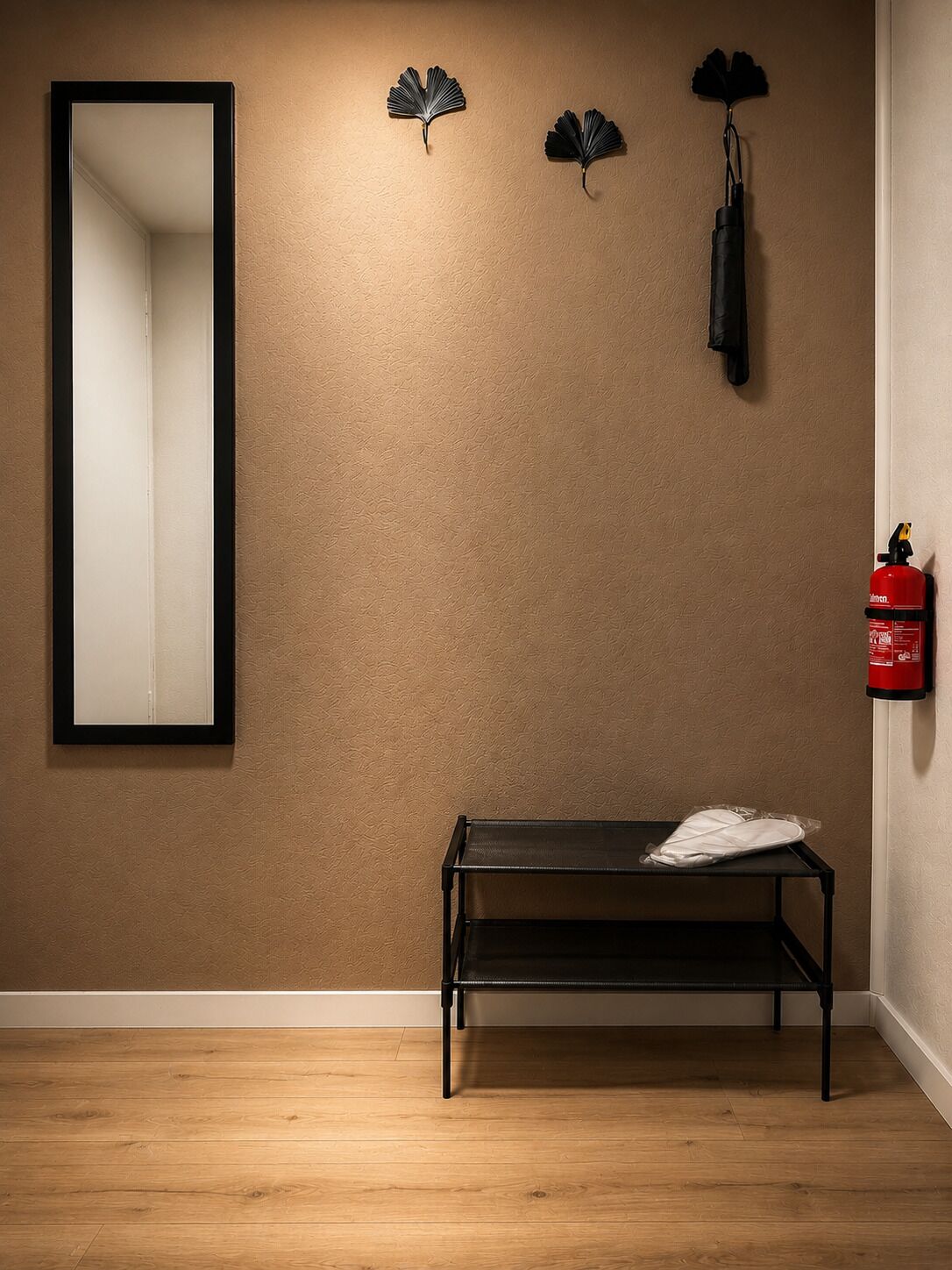 Ein Zimmer mit Holzboden, einer Bank, einem Spiegel und einem Feuerlöscher an der Wand.