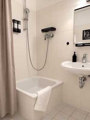 Ein modernes Badezimmer mit Badewanne, Dusche und Waschbecken.