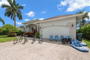 Ein Wohnhaus mit Garage, Fahrrädern und Sitzgelegenheit im Freien.