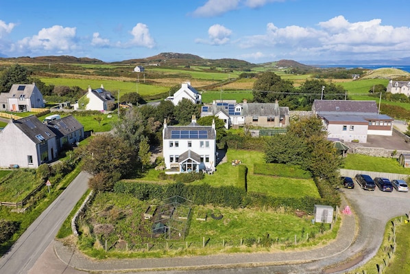 A residential area with houses, a road, and a hilly landscape in the background.