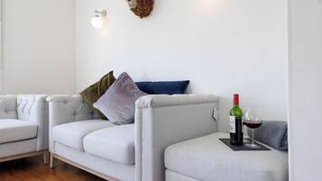 A modern living room with a sofa set, decorative wall art, and a wine bottle on a small table.