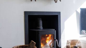 A room with a fireplace, a woven basket, and a heart-shaped sign with a Wi-Fi password.