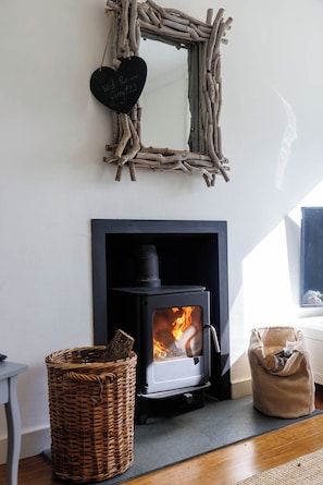 A room with a fireplace, a woven basket, and a heart-shaped sign with a Wi-Fi password.