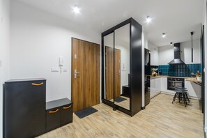 Eine moderne Küche mit Holztür, einem schwarzen Schrank und einem Barhocker.
