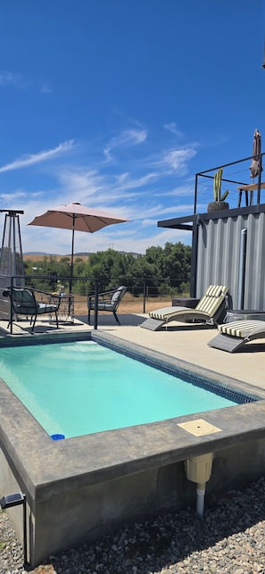 A swimming pool with lounge chairs and umbrellas, surrounded by a patio area. - Villa Boutique(+12) Alberca privada Valle de Gpe (San antonio de las minas)