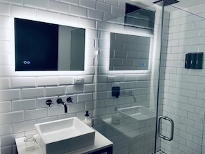 A modern bathroom with a glass shower enclosure, a white sink, and a mirror above it. - Villa Boutique(+12) Alberca privada Valle de Gpe (San antonio de las minas)