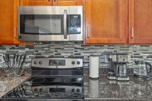 A kitchen with a stainless steel microwave, a double oven, and a coffee maker. - Casa de Arizona: 3 BR Luxury Stay + King Bed (Gilbert)