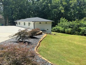 A residential property with a well-maintained lawn, a small shed, and a gravel path leading to a wooden deck. - Modern 4BR/3BA Retreat Near East Lake & Downtown Decatur (decatur)