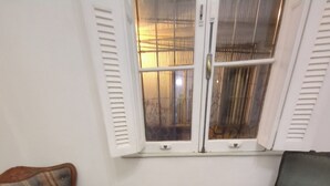 Una habitació amb un sofà estampat, una cadira i una taula de centre de vidre.